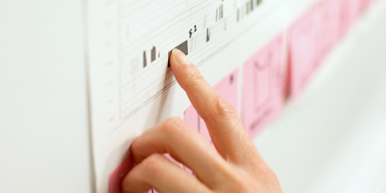 Single index finger pointing up to data on a chart