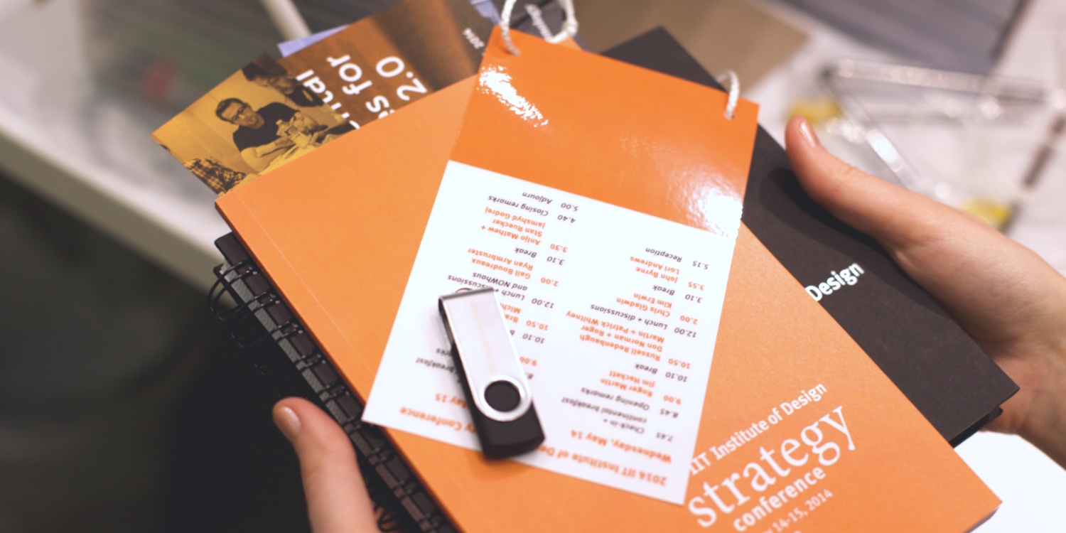 Conference swag with USB drive, booklet, and notebook related to design