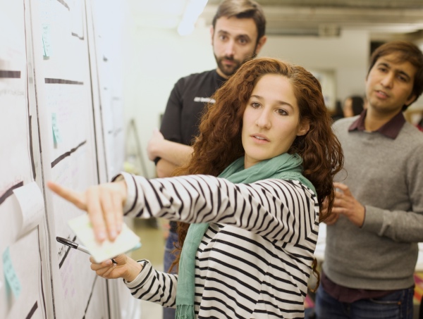 User Experience consultants pointing to and discussing product insights at the wall